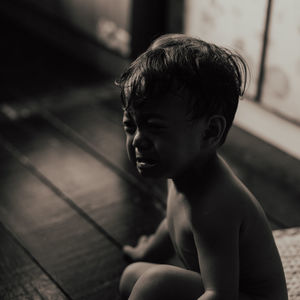 Portrait of shirtless boy sitting at home