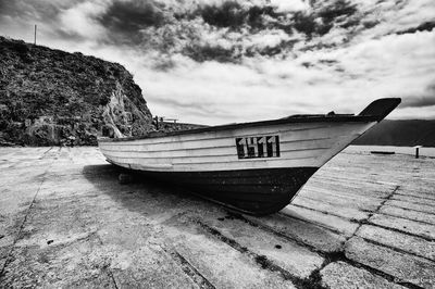 Boat moored at beach against sky