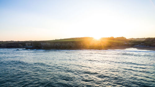 Scenic view of sea against clear sky during sunset