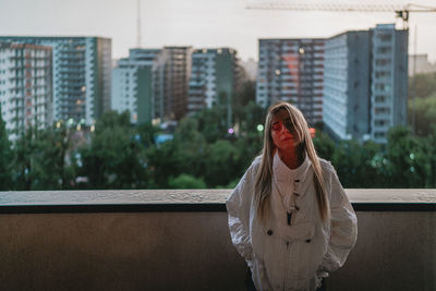 Portrait of young woman standing in city