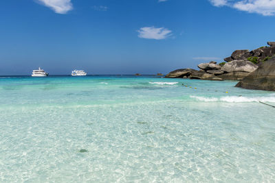 Sailboats on sea shore against sky