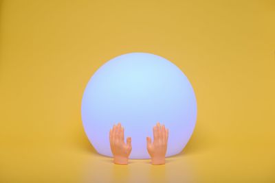 Close-up of light bulb against yellow background