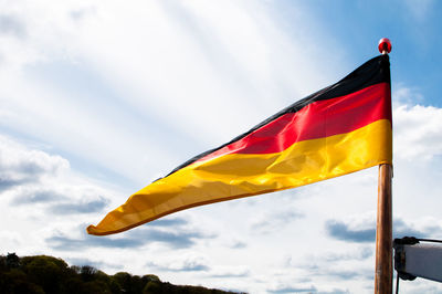 German flag waving against cloudy sky