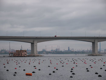 Bridge over river against cloudy sky