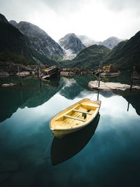 Boat moored on lake against sky