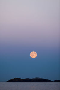 Scenic view of sea against moon at dusk