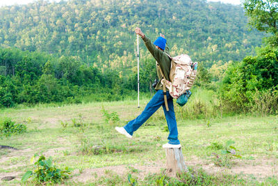 Full body man standing on field with forest and mountains traveling isolated