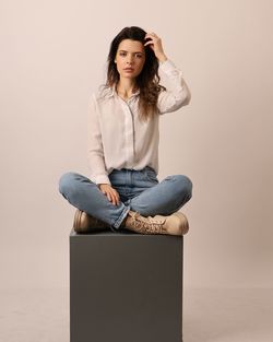 Portrait of young woman sitting on sofa at home