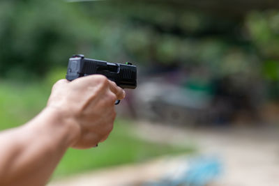 Cropped hand of man holding camera