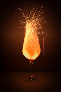 Close-up of illuminated glass against black background