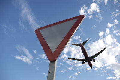 Low angle view of road sign against sky