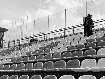 Rear view of people walking in row against sky