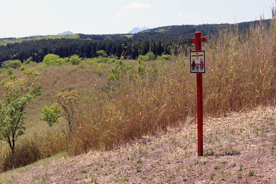 Information sign on field against sky