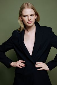 Portrait of young woman standing against wall