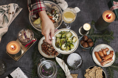 Hand holding plate with brussel sprouts over christmas table