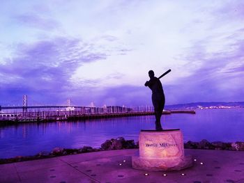 Statue of woman by sea against sky