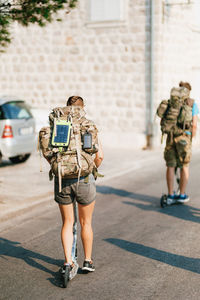 Rear view of people walking on street in city
