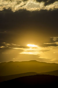 Scenic view of silhouette mountains against sky during sunset