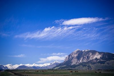 Scenic view of mountains against blue sky