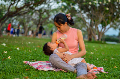 Rear view of women sitting on grass