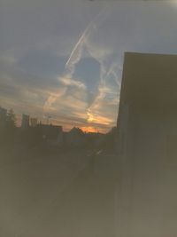 Built structures against sky at sunset