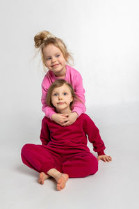 Portrait of cute girl playing with toy on white background