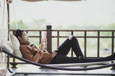 Young man sitting on railing