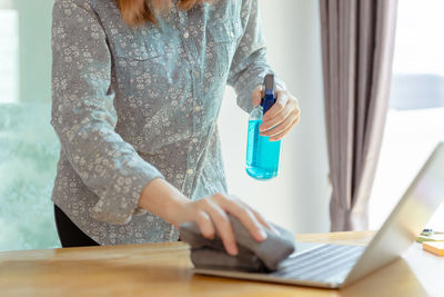 Midsection of woman working on table at home