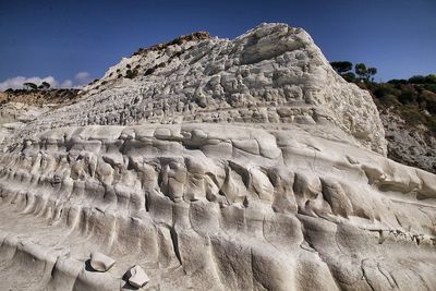 Low angle view of rock formations against sky