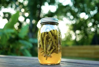 Close-up of pickled green beans in a jar on a table