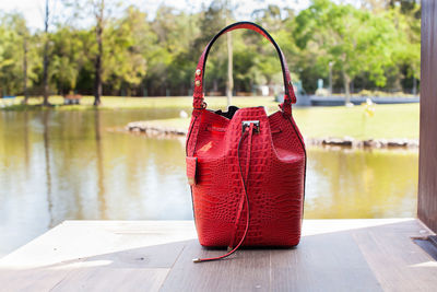 Close-up of red hanging on table by lake