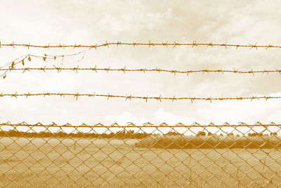 Low angle view of chainlink fence against sky