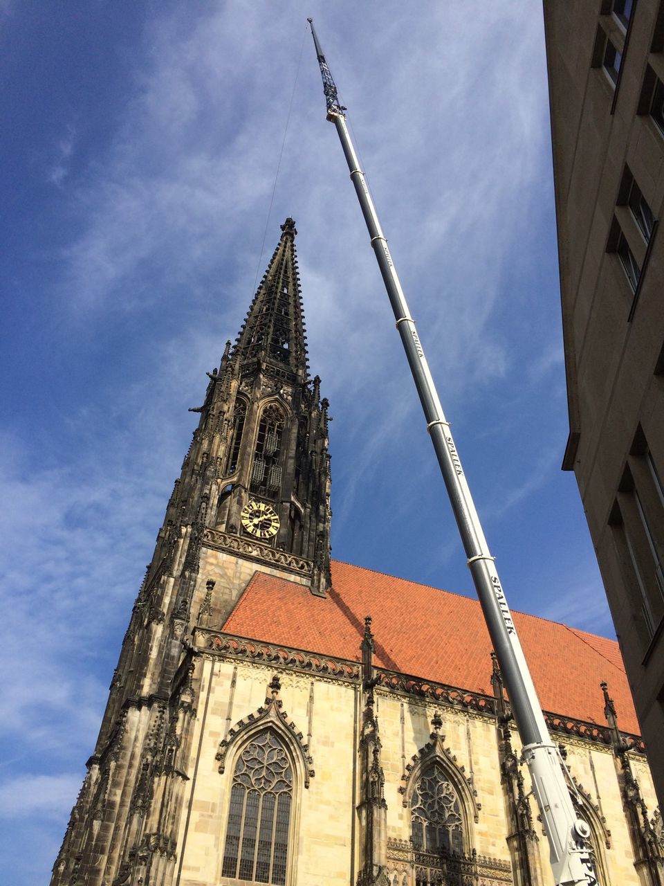 architecture, low angle view, building exterior, built structure, religion, place of worship, church, spirituality, sky, cathedral, tower, history, steeple, clock tower, cloud - sky, city, blue, outdoors