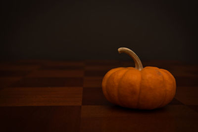 Close-up of pumpkin on table against black background