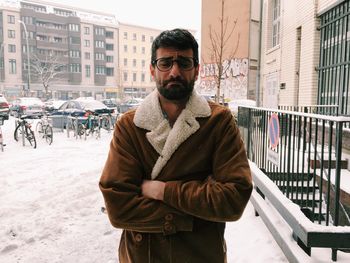 Man making face while standing on snow during winter