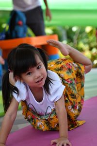 Portrait of smiling girl sitting outdoors