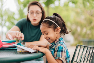 Young millennial mother sending daughter off back to school