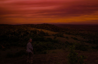 Man standing on mountain against sky during sunset