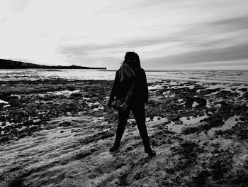 Rear view of woman walking on beach