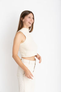 Portrait of young woman standing against white background