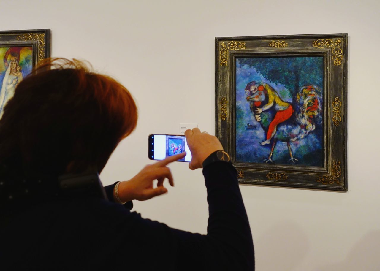 PORTRAIT OF WOMAN PHOTOGRAPHING WITH SMART PHONE ON MIRROR