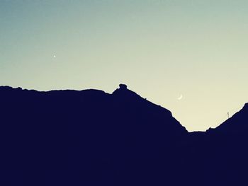 Low angle view of silhouette mountain against sky at sunset