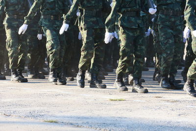 Low section of soldiers walking on road