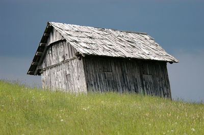 Abandoned house on field against sky