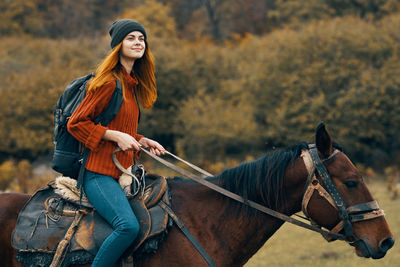 Young woman riding horse