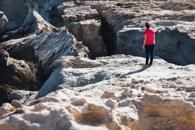 Rear view of woman standing on cliff