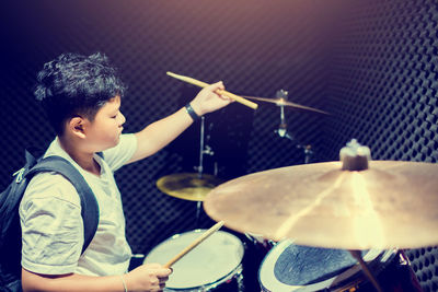 Rear view of boy playing piano at music concert