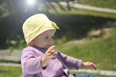 Close-up of baby girl sitting on land in park