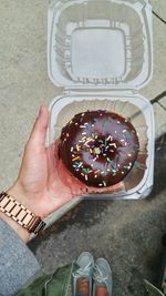 Low section of man holding donut on street