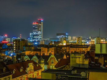 Illuminated buildings in city against sky at night